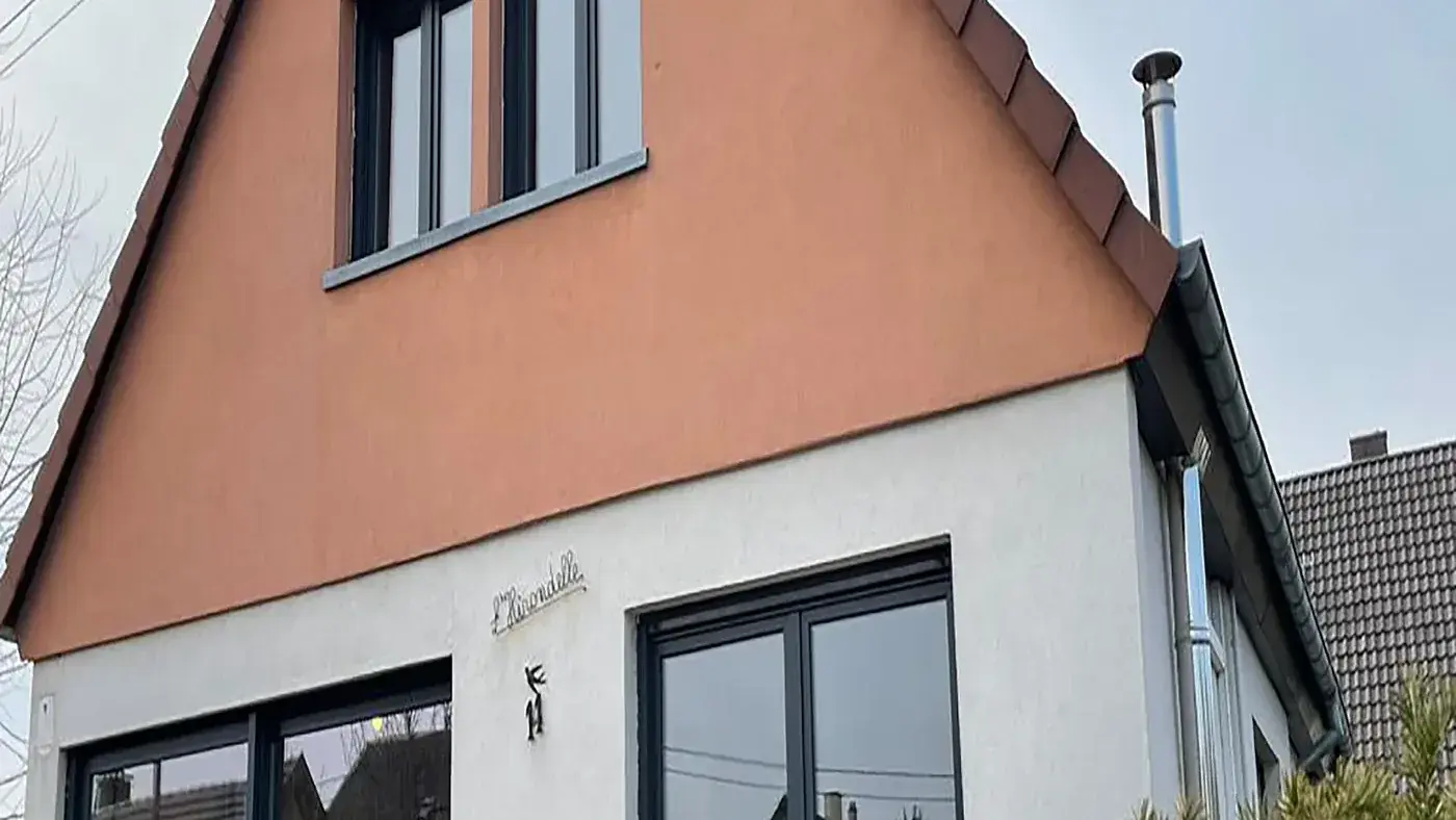 La même maison après travaux : ouvertures agrandies et menuiseries anthracite, façade reprise