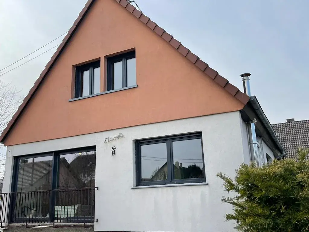 La même maison après travaux : ouvertures agrandies et menuiseries anthracite, façade reprise