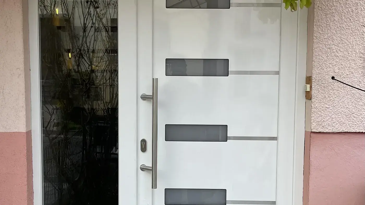 Porte d'entrée PVC blanche à inserts gris posée dans le même tableau