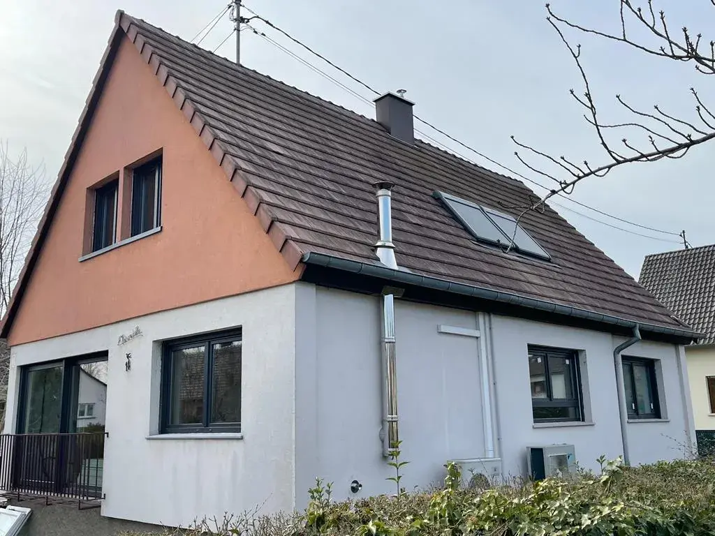 Maison alsacienne blanche à toit de tuiles brunes avec fenêtres anthracite neuves