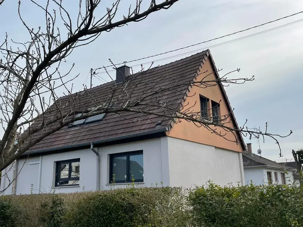 Maison alsacienne au crépi rose et blanc, équipée de fenêtres neuves à cadre anthracite
