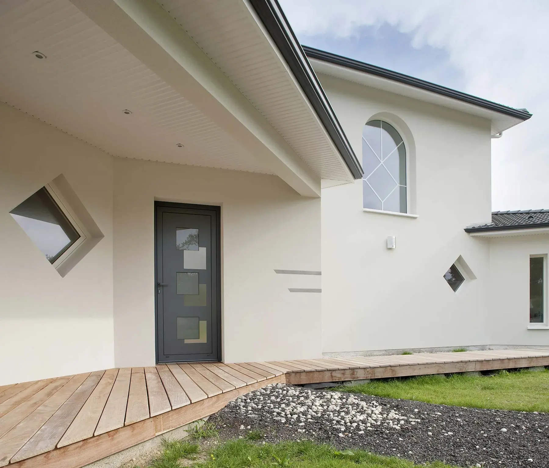 Maison de plain-pied blanche avec porte d'entrée aluminium et fenêtre en losange